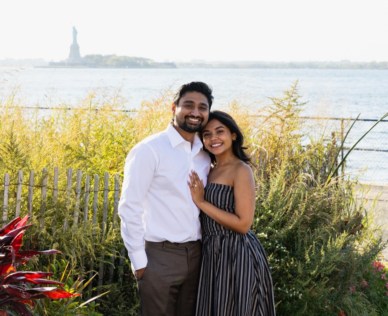 Dhruv and Hely by the New York harbor, the Statue of Liberty behind them